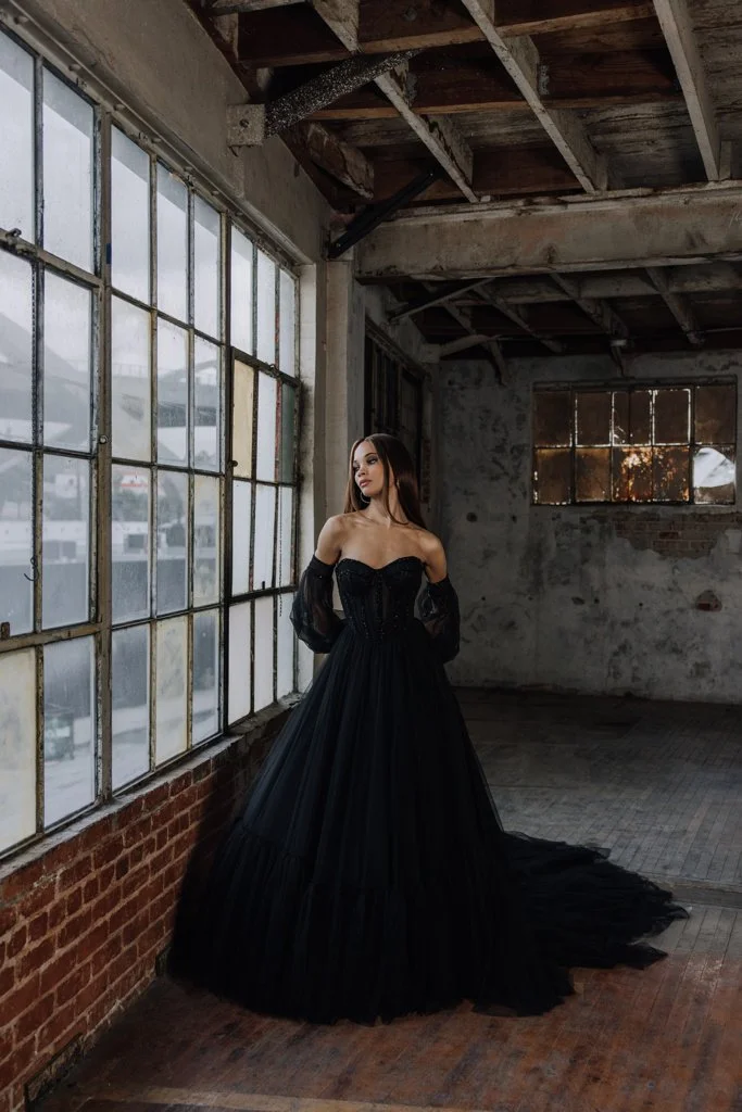 Serene Ame Andorra ballgown wedding dress with V-waistline, beaded trim, detachable puff sleeves, and raw tulle tiered skirt.