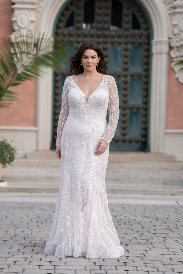 Allure Bridals W549 plus size beaded fit and flare wedding gown with plunging V-neckline, sheer long sleeves, and intricate pearl and sequin embellishments over tulle.