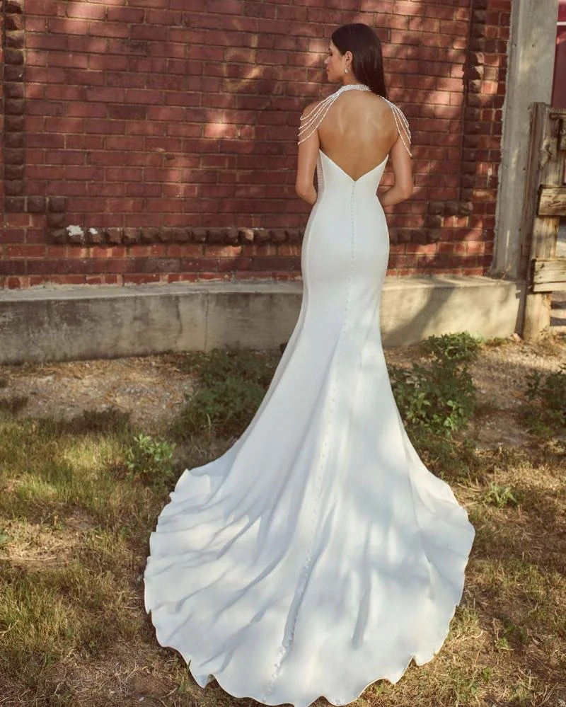La Perle Kya boho lace A-line wedding dress with deep V-plunge neckline, detachable long sleeves, tank straps, and long train.