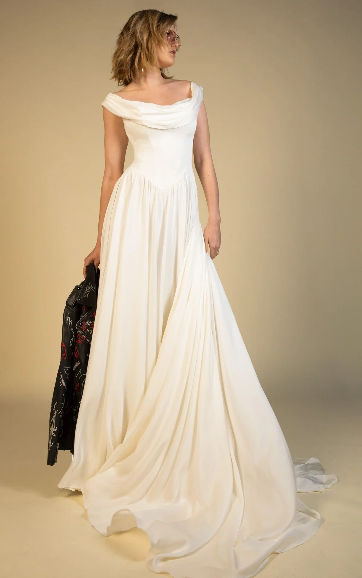 All Who Wander Cosete off-the-shoulder A-line wedding dress in silk double georgette with draped wrap bodice, dropped basque waist, and low V-back, available at Bride To Be Couture in Sacramento