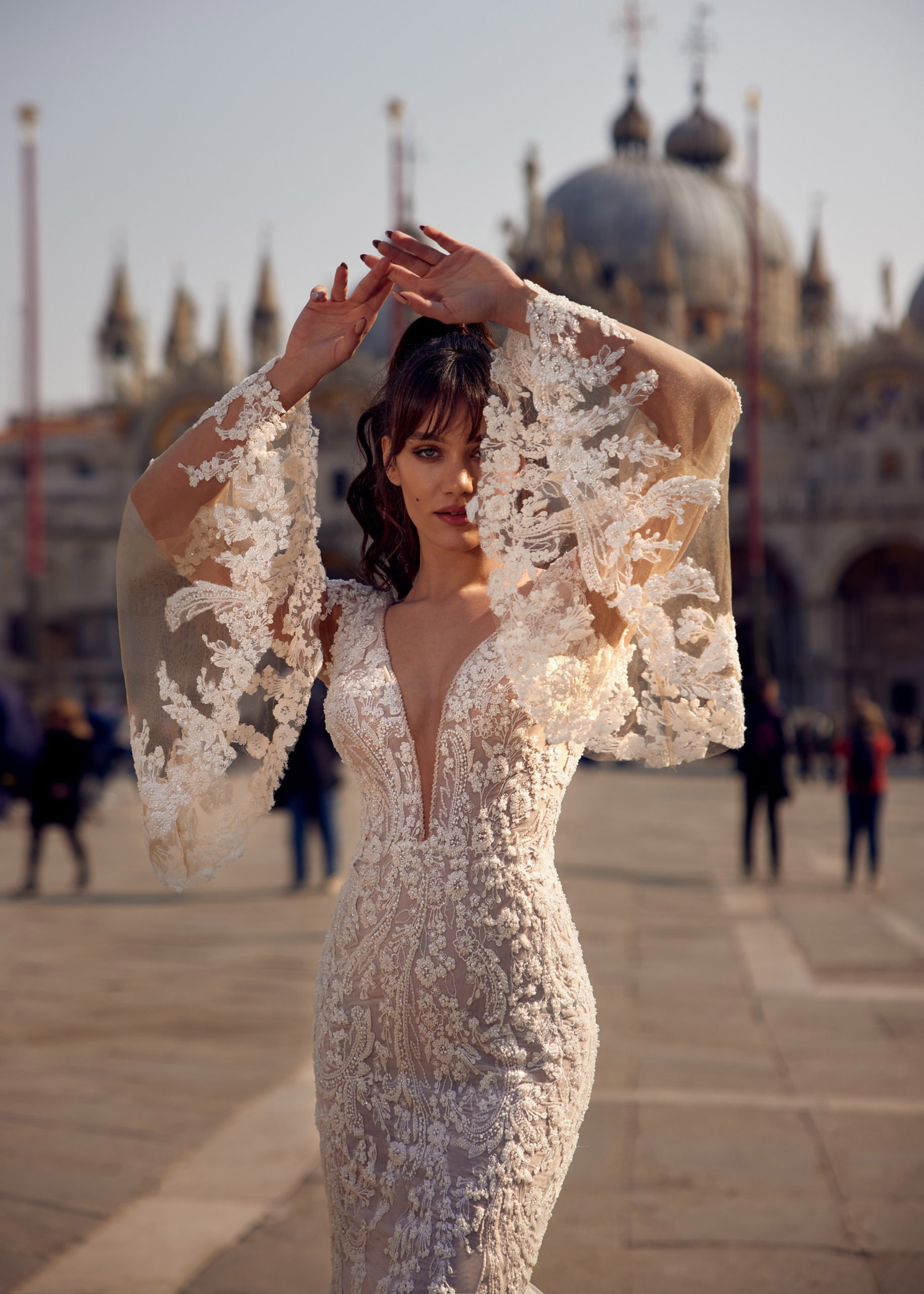 Madam Burcu Style 3022 mermaid wedding gown with plunging V-neck, sheer long lace sleeves, and floral lace embroidery on blush base