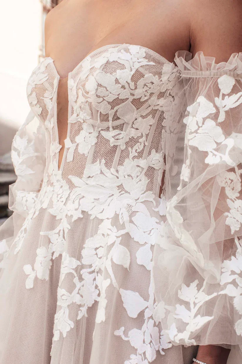Madison James Harper lace A-line wedding dress with detachable puffed tulle sleeves and romantic lace detailing throughout.