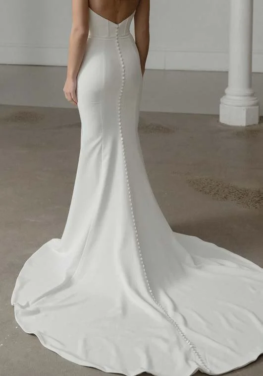 Madi Lane Savoy fit-and-flare wedding dress with a cat-eye sweetheart neckline, exposed boning, and detachable off-the-shoulder lace sleeves with an oversized bow train.