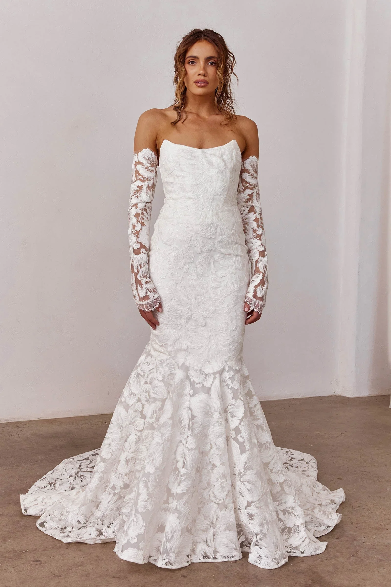 Off-the-shoulder mermaid gown in dimensional floral embroidered lace with flexi boning and removable straps.