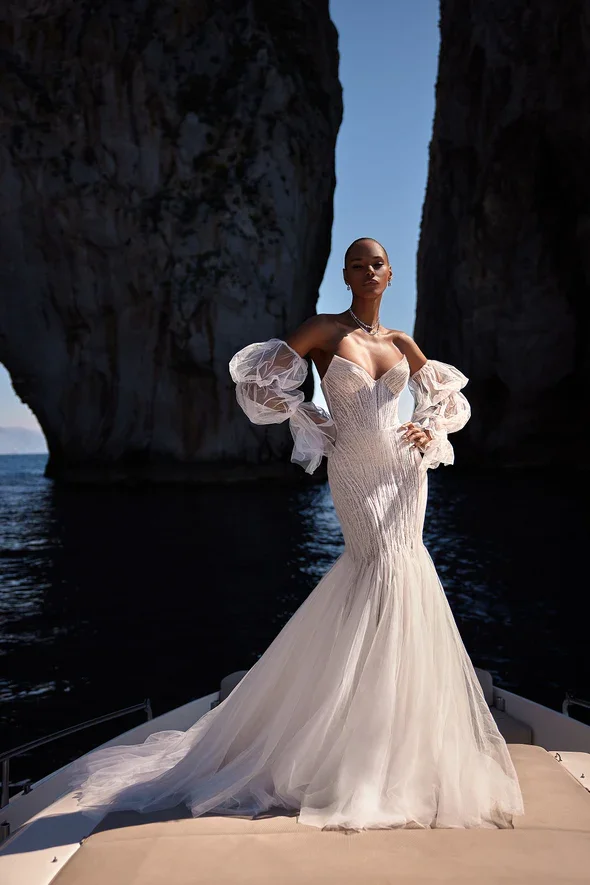 Julie Vino Marissa fit-and-flare wedding gown with a strapless sweetheart cat-eye neckline, off-the-shoulder long puff sleeves, and beaded lace over tulle.