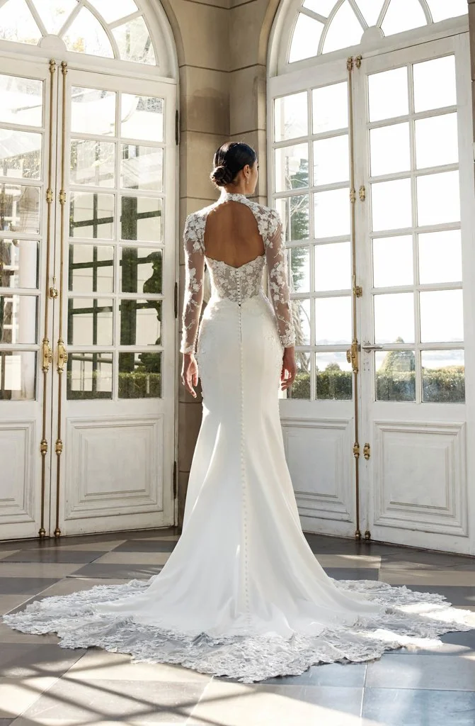 Shop Denver by Jeune at Bride To Be Couture in Sacramento, California. This fitted lace wedding dress features illusion long sleeves, floral appliqués, and a romantic sculpted silhouette.