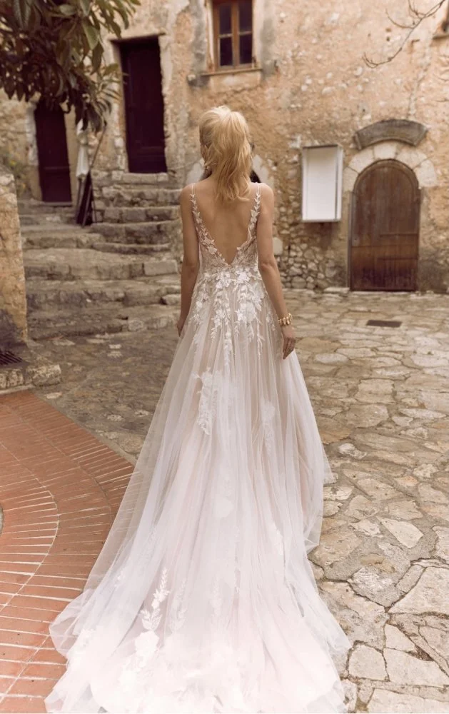 Madi Lane Halani A-line wedding gown with V-neck illusion straps, floral embroidered lace appliqué, and a scattering of sequin embellishments over soft layered tulle.