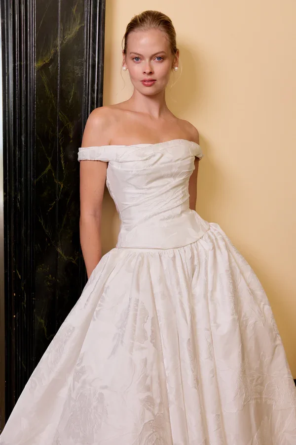 The Eloide gown, crafted from luxurious jacquard satin, features a chic two-piece design perfect for any wedding setting.