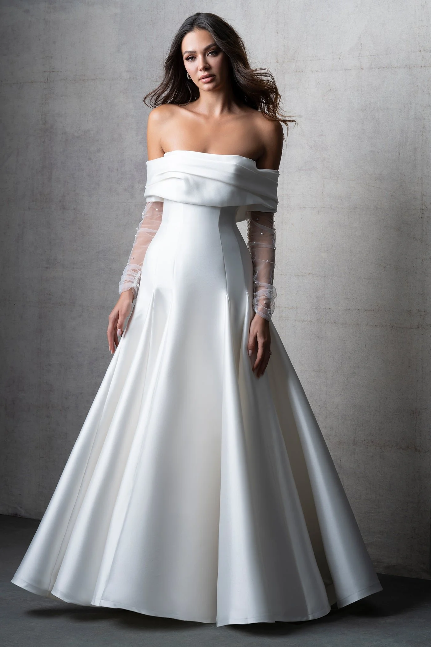 Allure Couture C750 architectural Mikado A-line wedding gown with subtly scooped neckline, dropped waist, and an optional detachable bardot neckline with sheer pearl-dotted long sleeves.