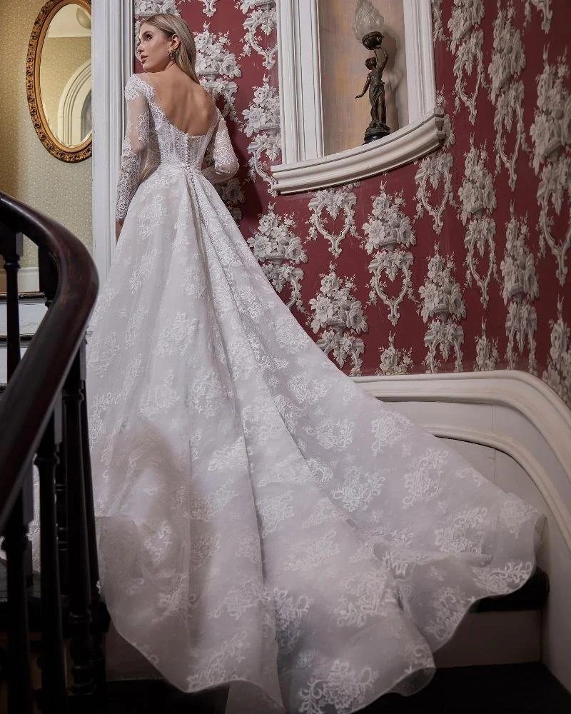 L'Amour Rio LA23230 lace A-line wedding dress with strapless sweetheart neckline, exposed corset boning, detachable long-sleeved jacket, pockets, and long train.