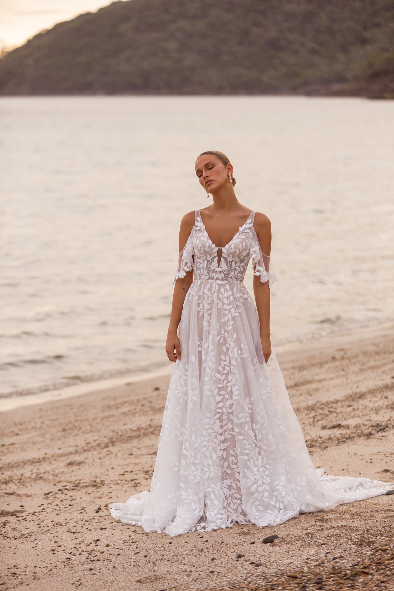 Madi Lane Jaya A-line wedding dress with a plunging V-neckline, detachable flutter illusion straps, and leaf-inspired lace scattered with sequins.