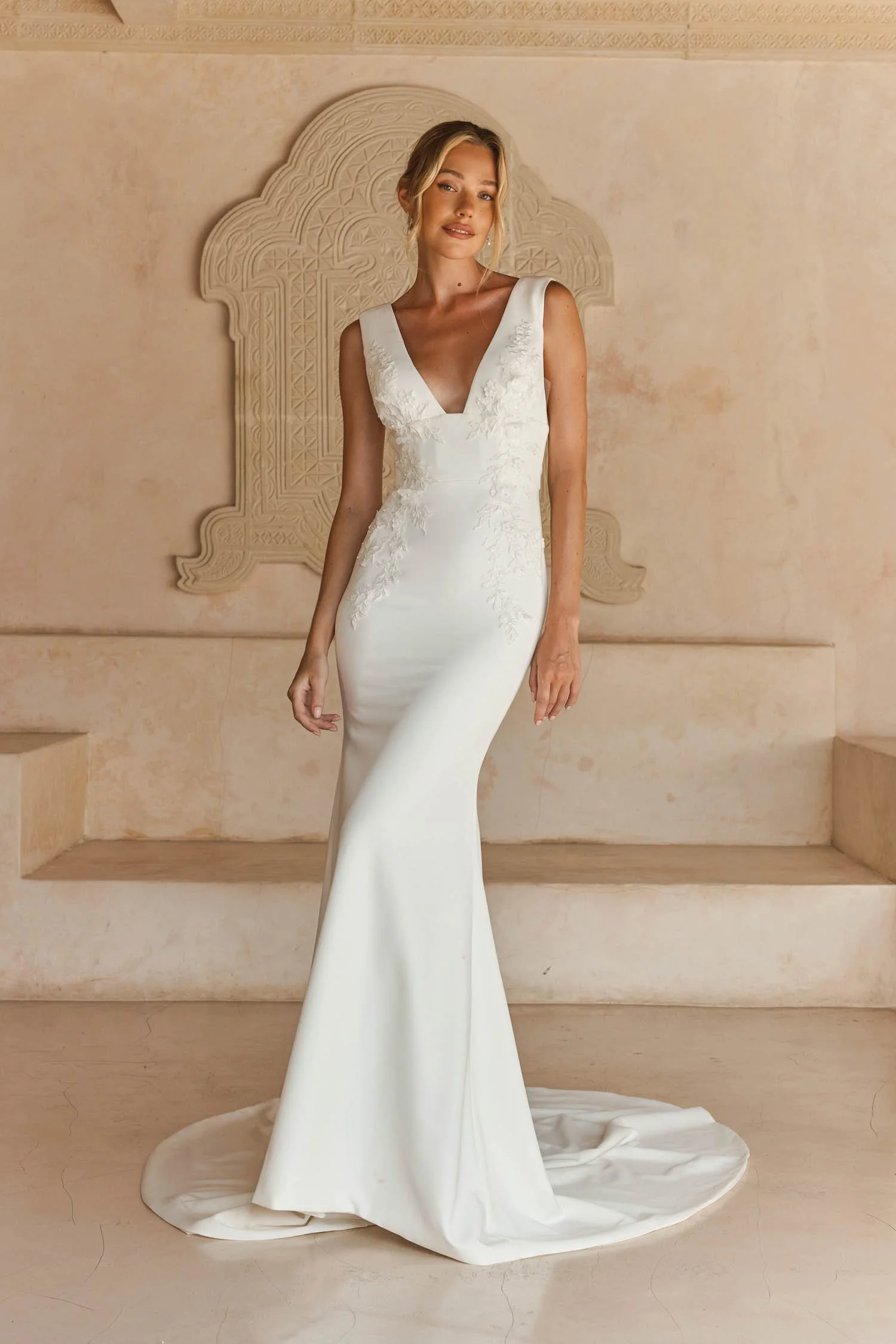 Madi Lane Lois sleek crepe fit-and-flare wedding dress with a V-neckline, V-back, beaded shoulder straps, and embroidered sequin 3D floral motifs.