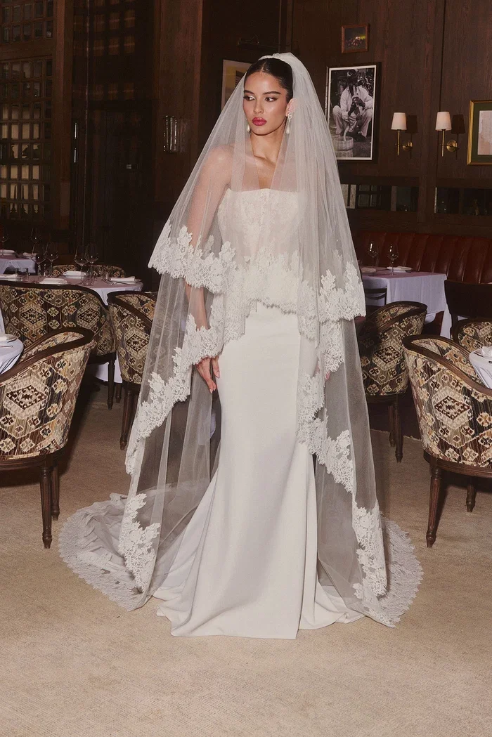 Stretch crepe sheath gown with structured lace-collaged bustier and center back crepe godet.