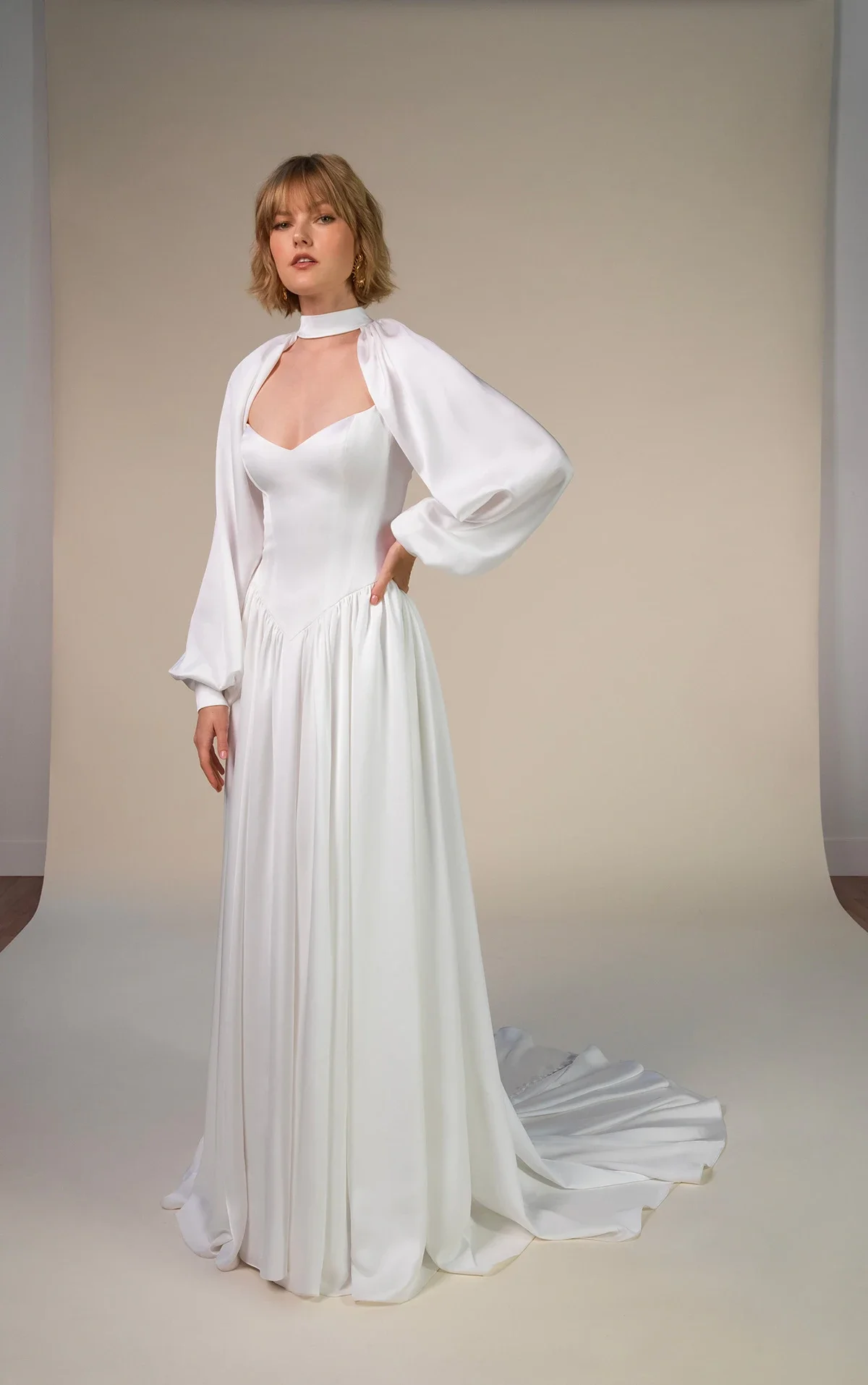 All Who Wander Keira satin A-line wedding dress with spaghetti straps, sweetheart neckline, basque waist, and detachable blouson sleeves, available at Bride To Be Couture in Sacramento.