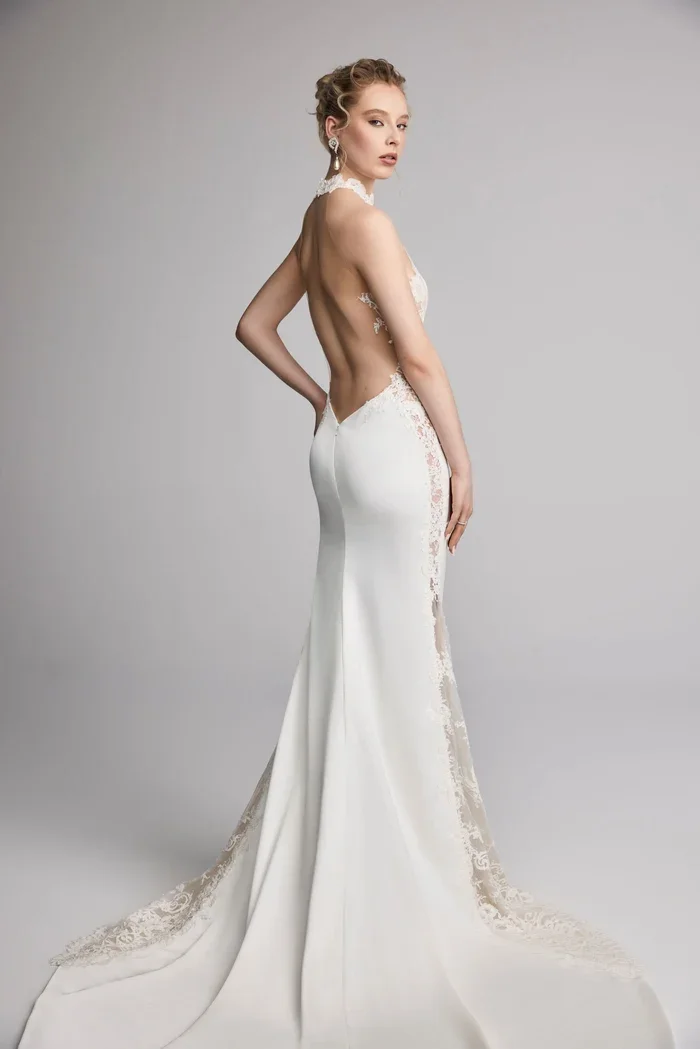 Halter neckline sheath with accentuated godet in back. Paired with opulent flowing sleeves.