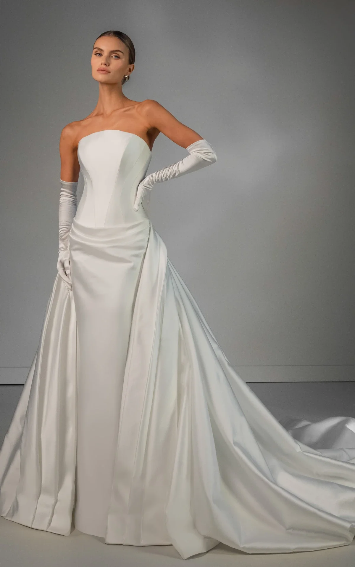 Martina Liana Luxe LE1460 strapless satin wedding dress with corset bodice, column silhouette, dramatic overskirt, and opera gloves at Bride To Be Couture Sacramento