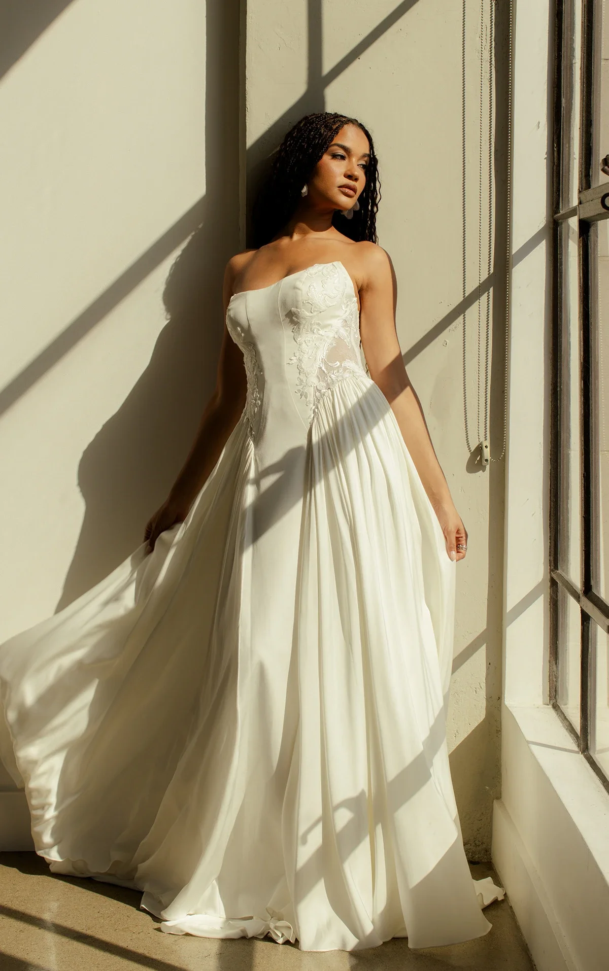 All Who Wander Romin strapless boho wedding dress in silk double crepe and lace with cat-eye neckline, side cutouts, and gathered chiffon hips, available at Bride To Be Couture in Sacramento.