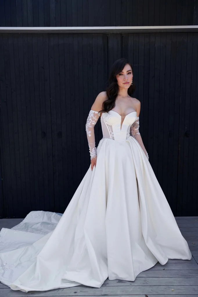 Serene Ame Broadway satin ballgown wedding dress with sweetheart bustier, sequin and beaded appliqués, bold side slit, and detachable off-shoulder long sleeves.