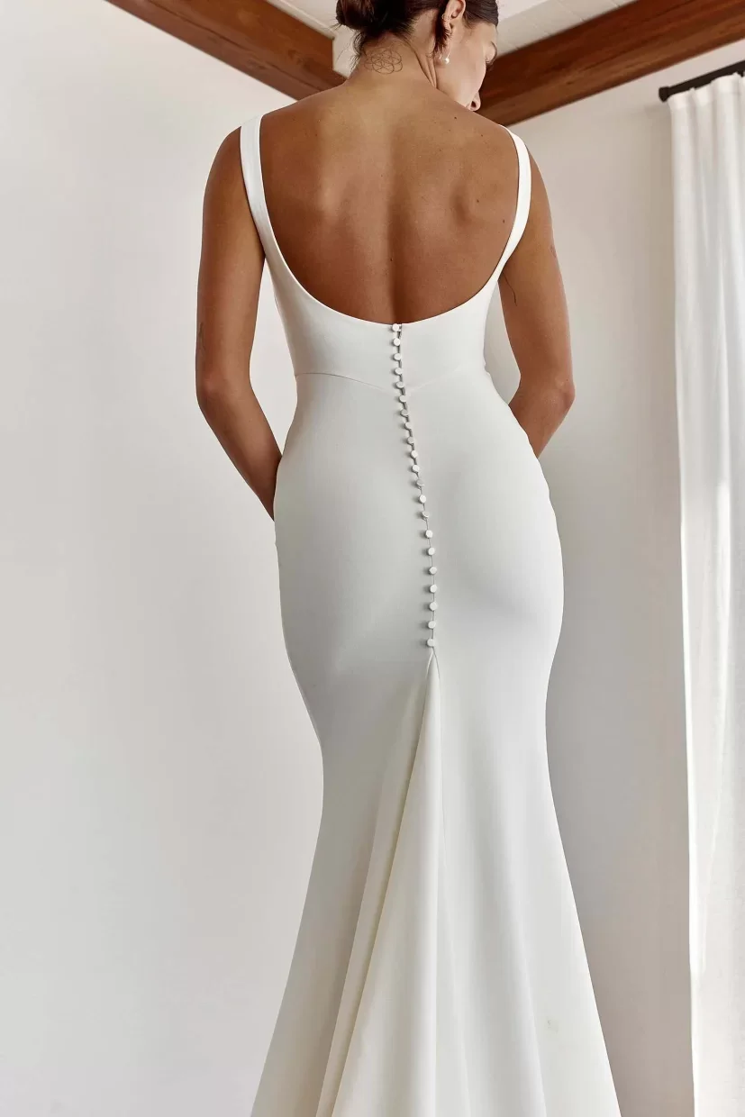 Grace by Grace Loves Lace Stretch crepe wedding dress with draped neckline, fitted silhouette, and low scoop back at Bride To Be Couture Sacramento