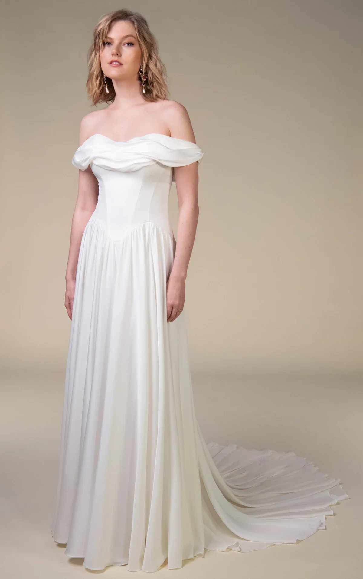 All Who Wander Cosete off-the-shoulder A-line wedding dress in silk double georgette with draped wrap bodice, dropped basque waist, and low V-back, available at Bride To Be Couture in Sacramento