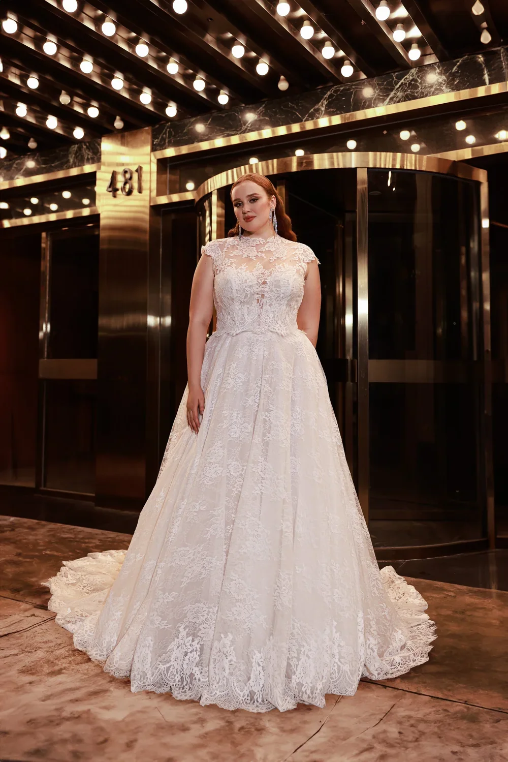 Dany Tabet Winslet DG0025W466 plus size vintage-inspired lace ballgown wedding dress with illusion high neckline, cap sleeves, and sweeping lace skirt.