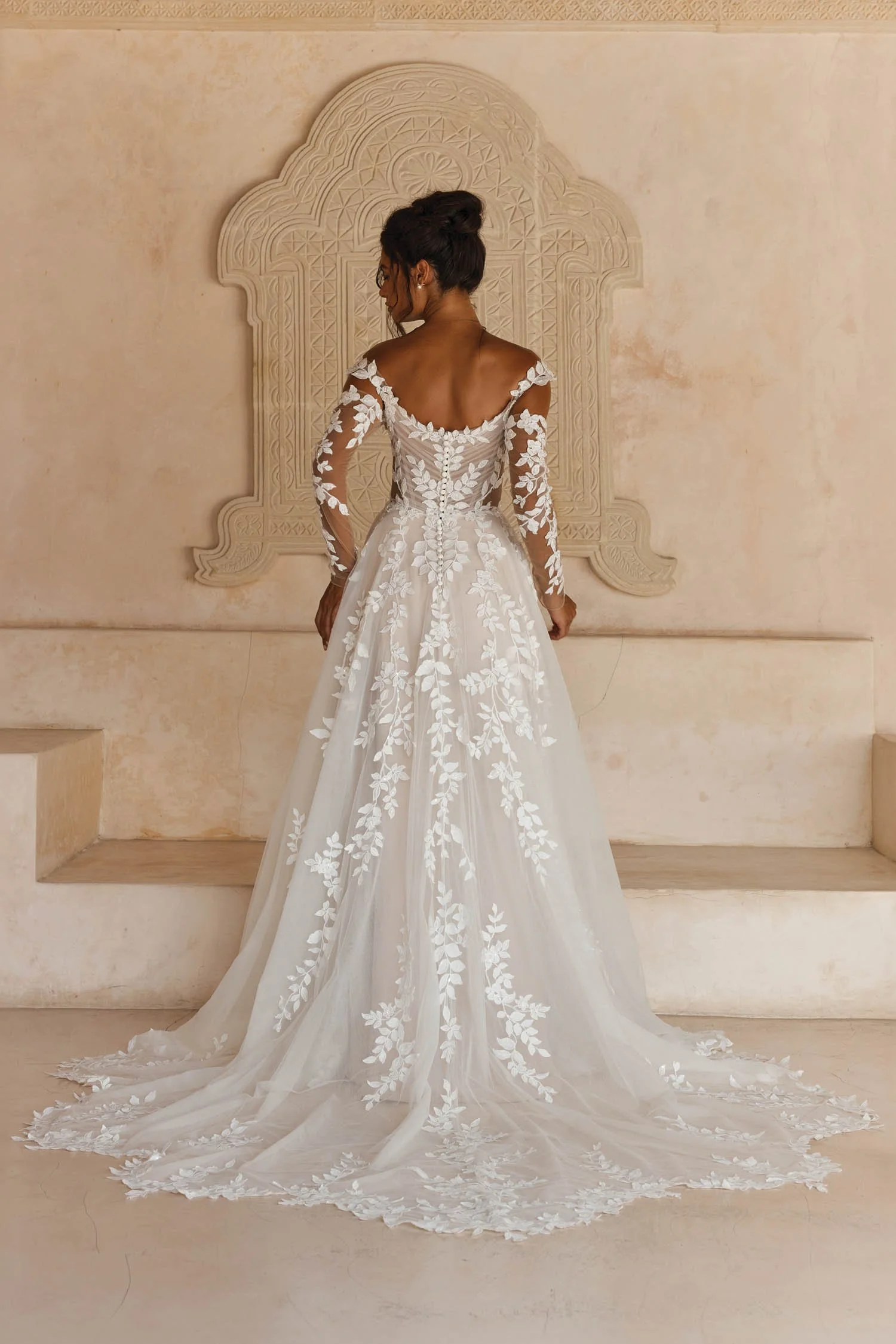 Madi Lane Landon A-line wedding dress with a pleated tulle illusion bodice, embroidered lace motif straps, detachable fitted long lace sleeves, and a floaty lace-cut hem.