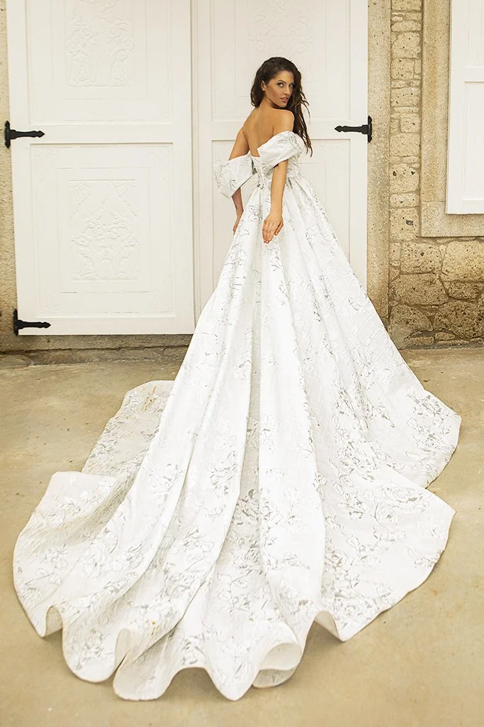 Oksana Mukha Amalia ball gown wedding dress with an off-the-shoulder V-neckline, beaded lace bodice, and natural waistline