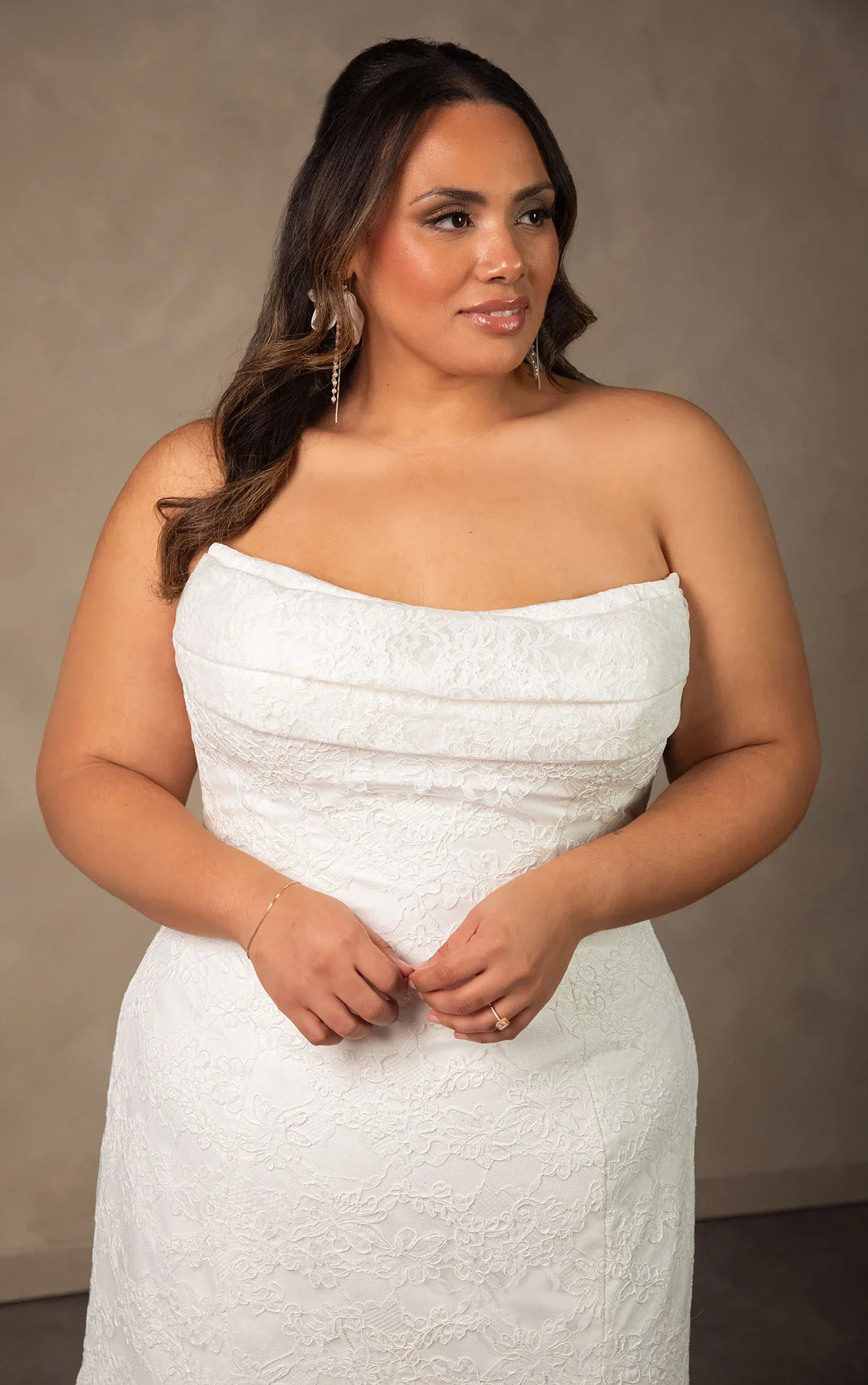 Essense of Australia D4522 romantic strapless allover lace fit-and-flare plus-size wedding gown with soft scoop neckline, ruched bodice, and semi-sheer scalloped lace train.