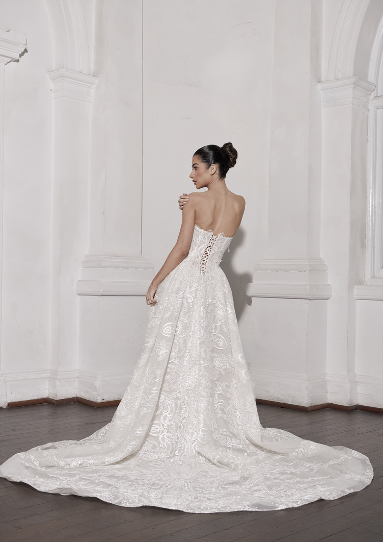 ROMANTIC STRAPLESS A-LINE WEDDING DRESS WITH EMBROIDERED LACE, CORSET BODICE, AND COUTURE TRAIN.