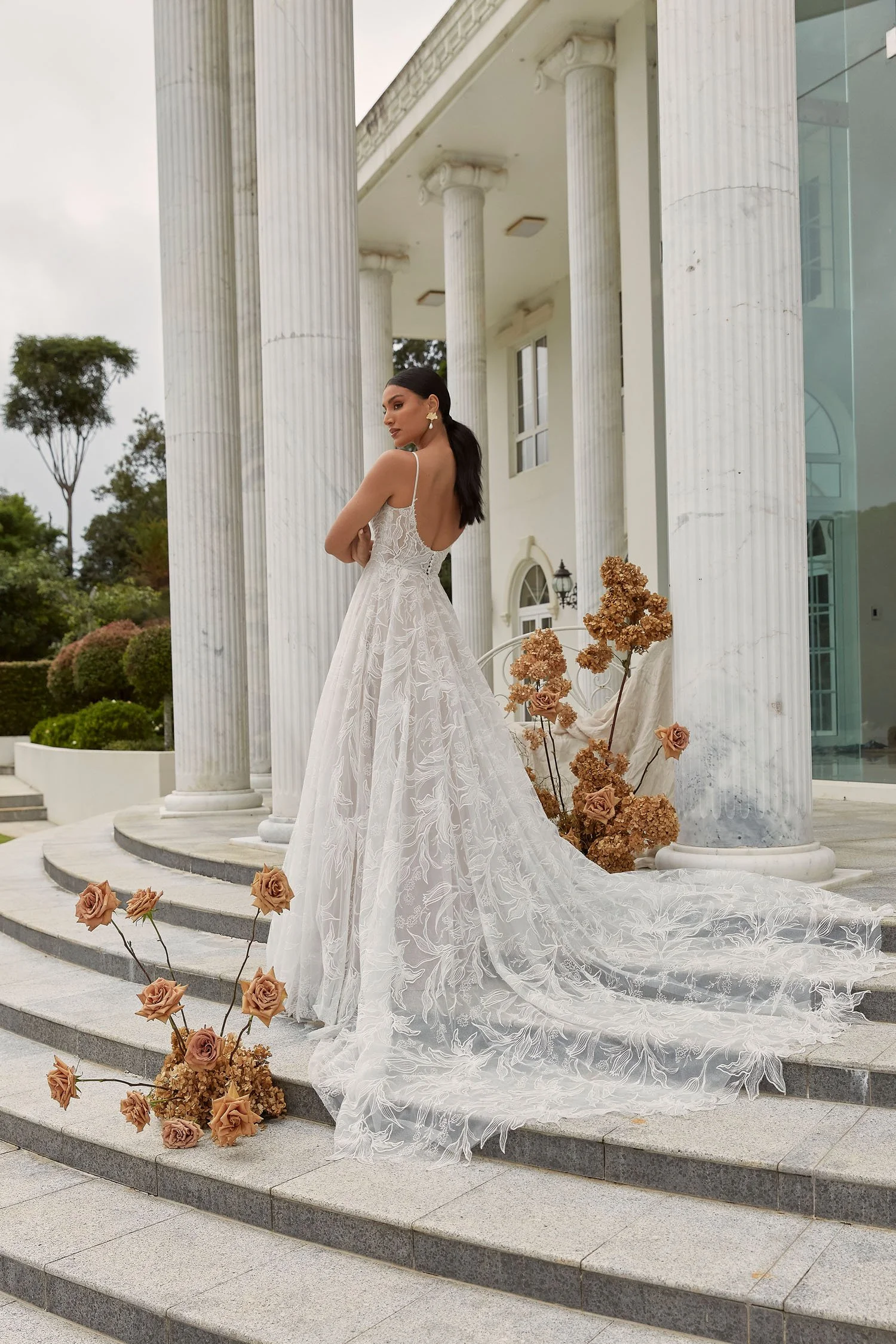 Madi Lane Dune A-line wedding dress with thin tulle straps, illusion scoop bodice, sweeping floral lace, and a dramatic 30-inch lace train.