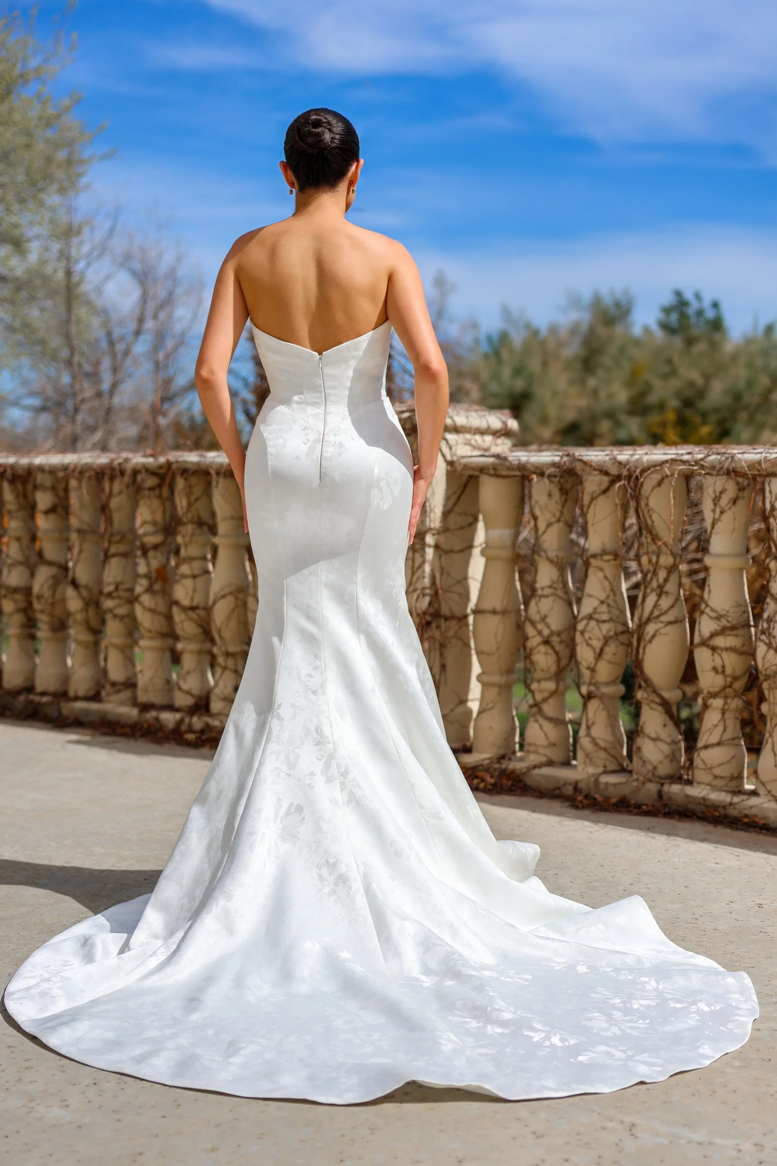 Elizabeth Lee Hunter sleek floral jacquard mermaid wedding dress with strapless straight neckline and dramatic sweep train.