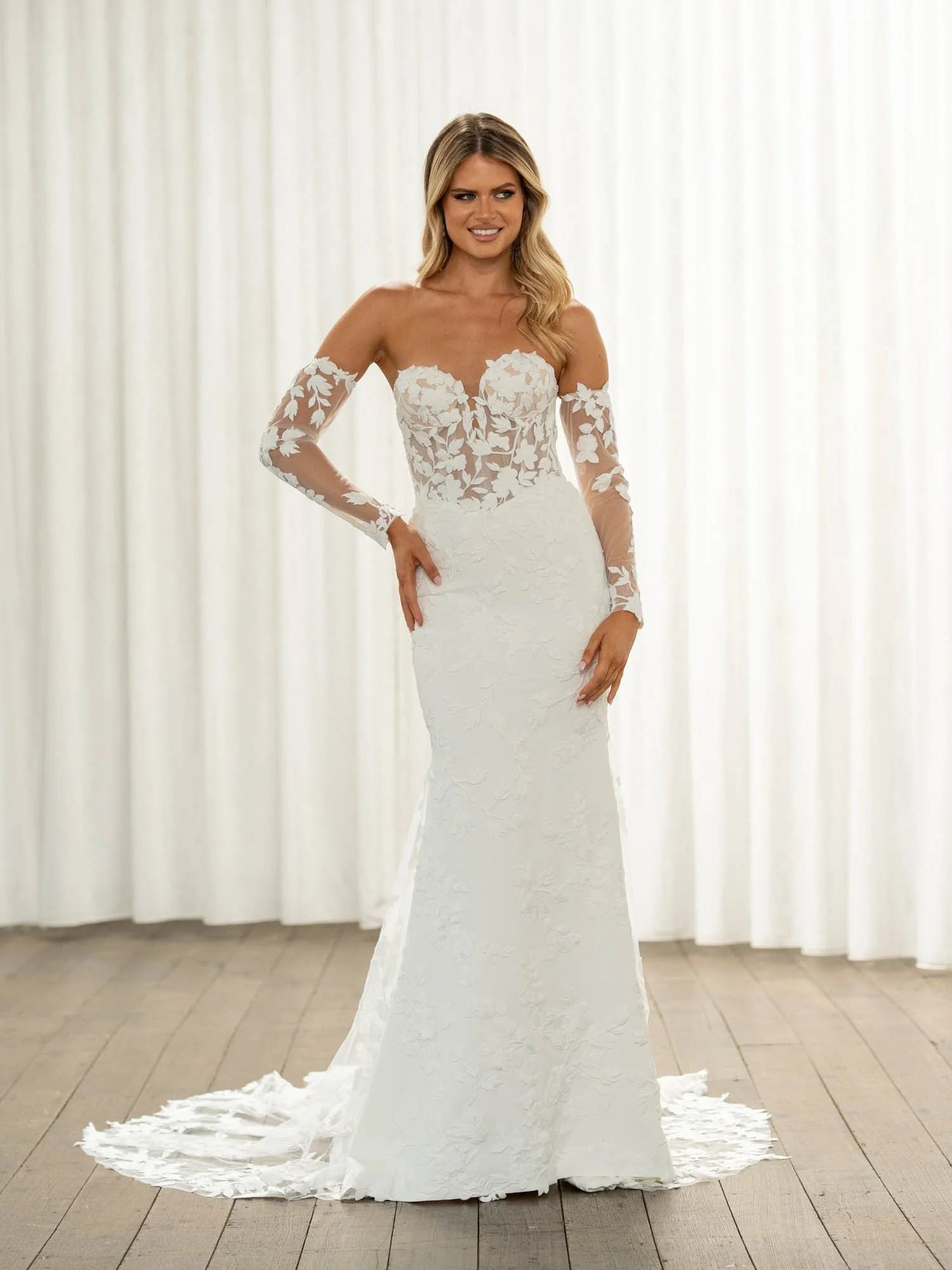 Madi Lane Thane CR  fit-and-flare wedding gown with a plunging sweetheart illusion bodice, vine and Chantilly lace, Basque waist, and detachable long lace sleeves.