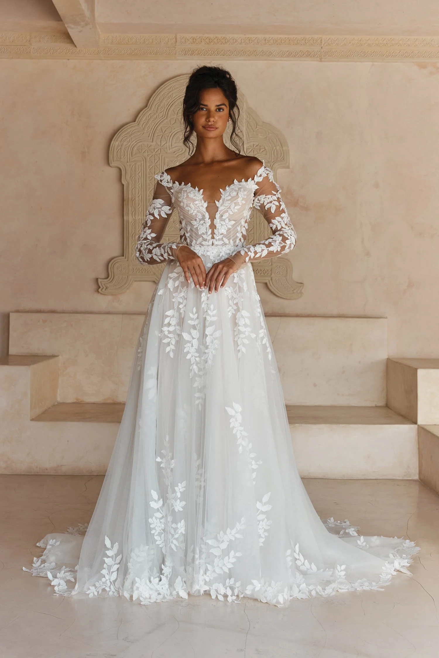 Madi Lane Landon A-line wedding dress with a pleated tulle illusion bodice, embroidered lace motif straps, detachable fitted long lace sleeves, and a floaty lace-cut hem.