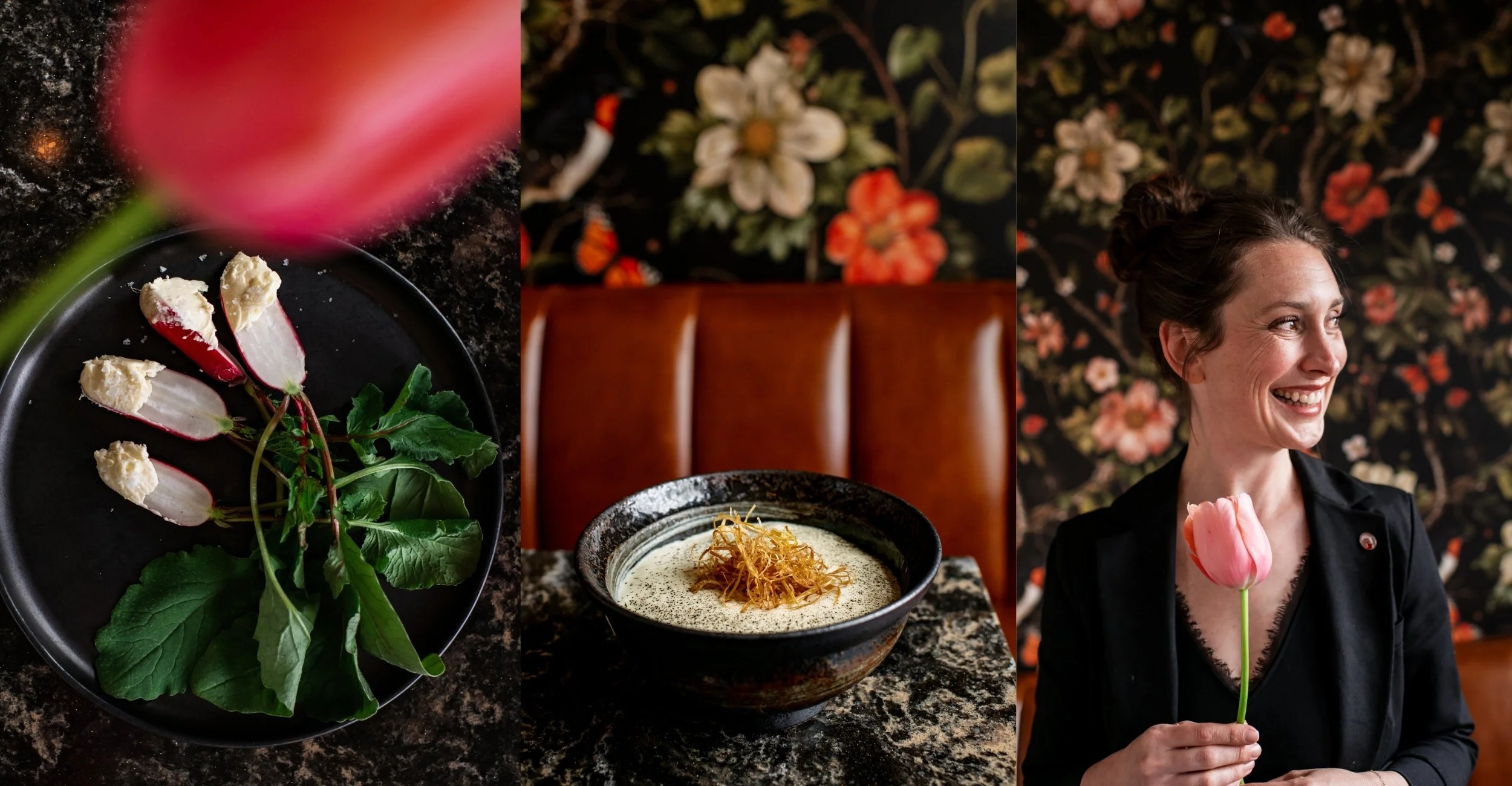 A woman holding a pink tulip in a restaurant with black floral wallpaper, with two bowls of food and a plate of radishes with greens on a dark granite table.