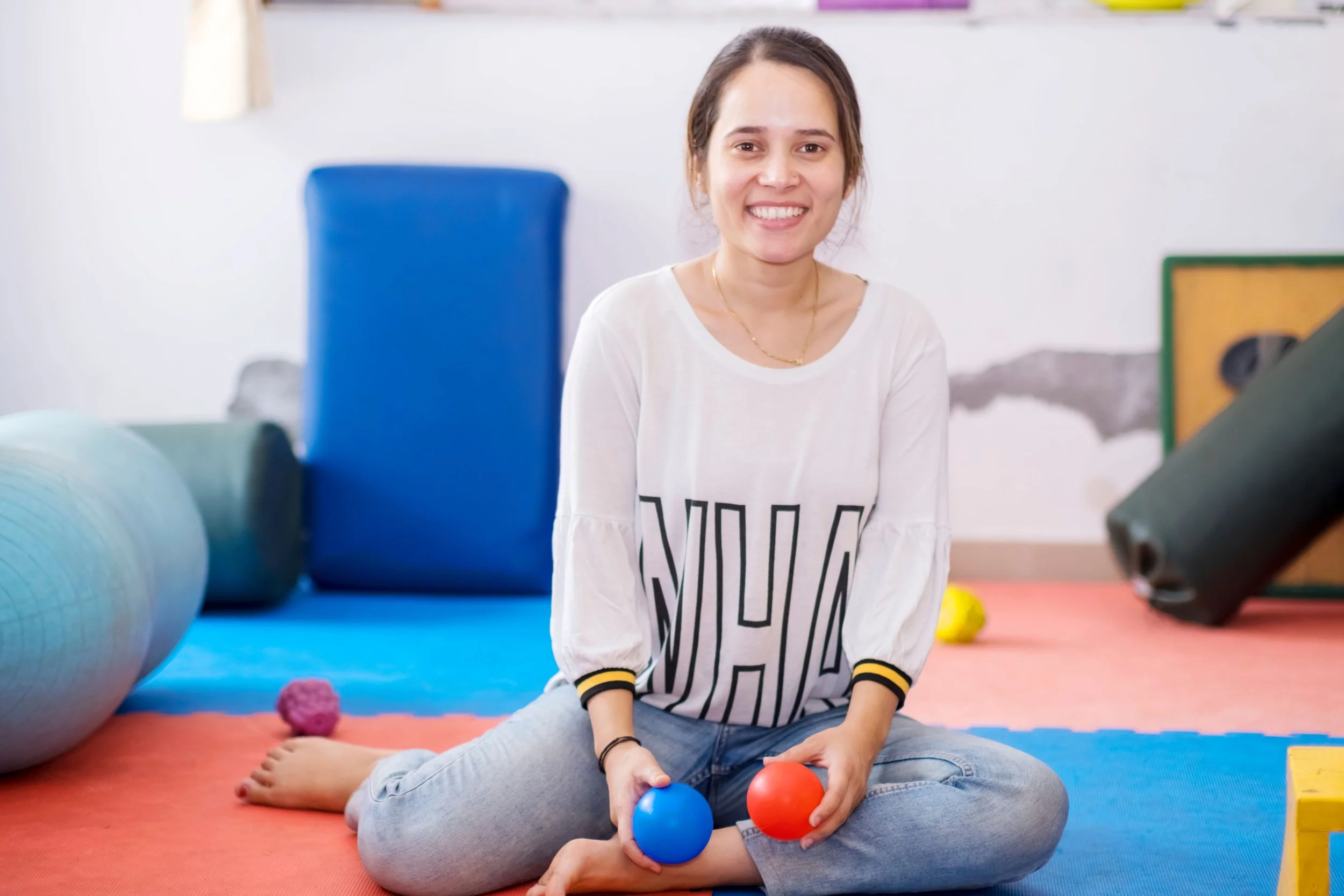a smiling woman holding therapy balls