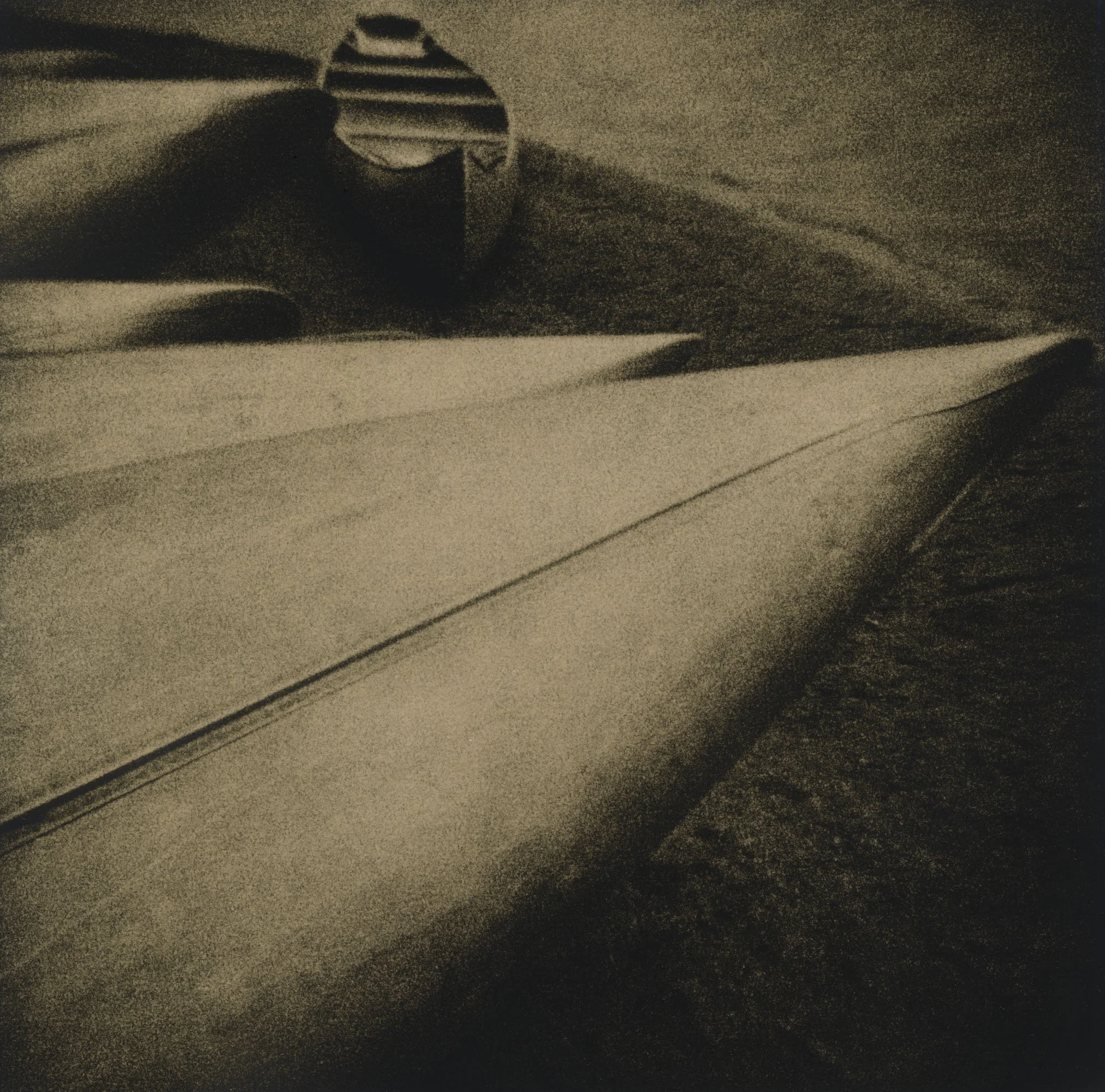 Close-up of an open book with a metallic ring on the edge of the pages, lying on a textured surface, with a dark and sepia-toned aesthetic.
