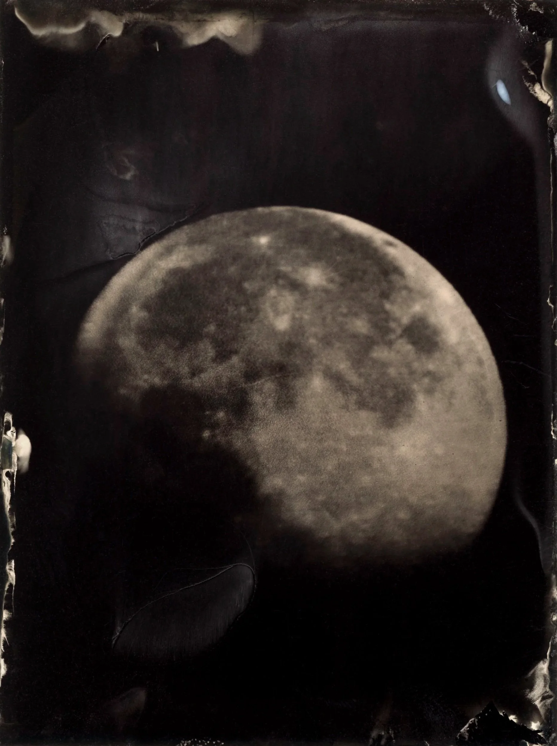 Black and white photograph of the moon, showing its craters and surface details.