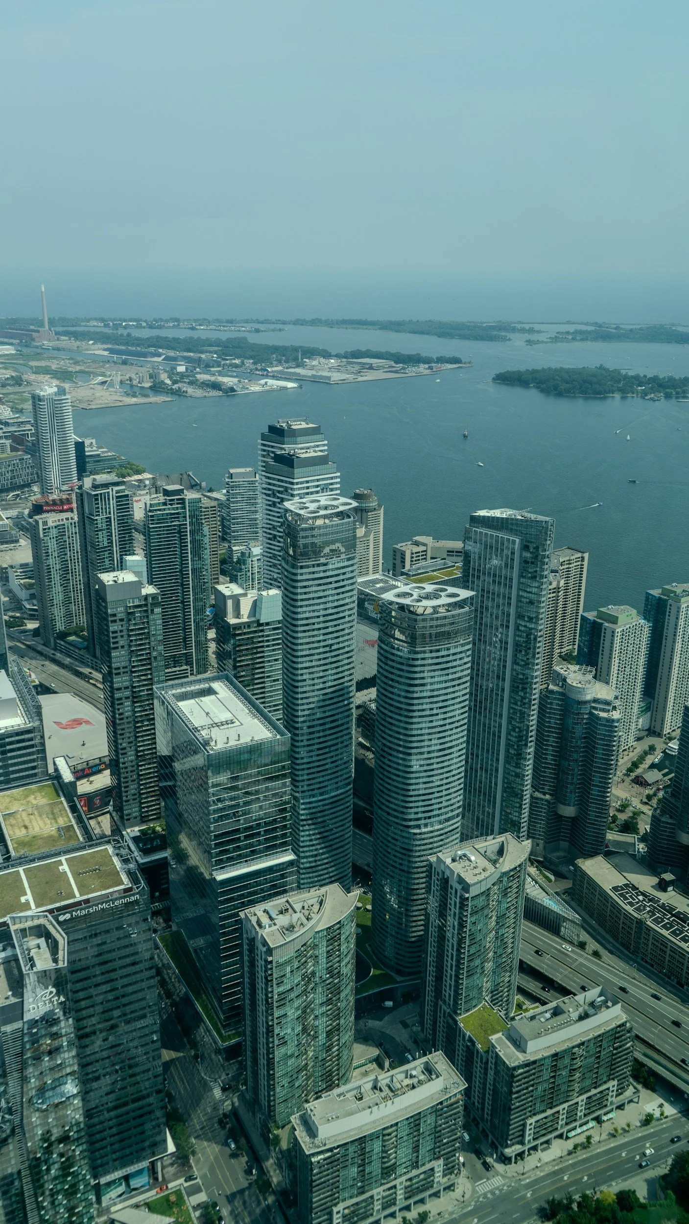 Aerial view of a city skyline with tall skyscrapers and a large body of water in the background.