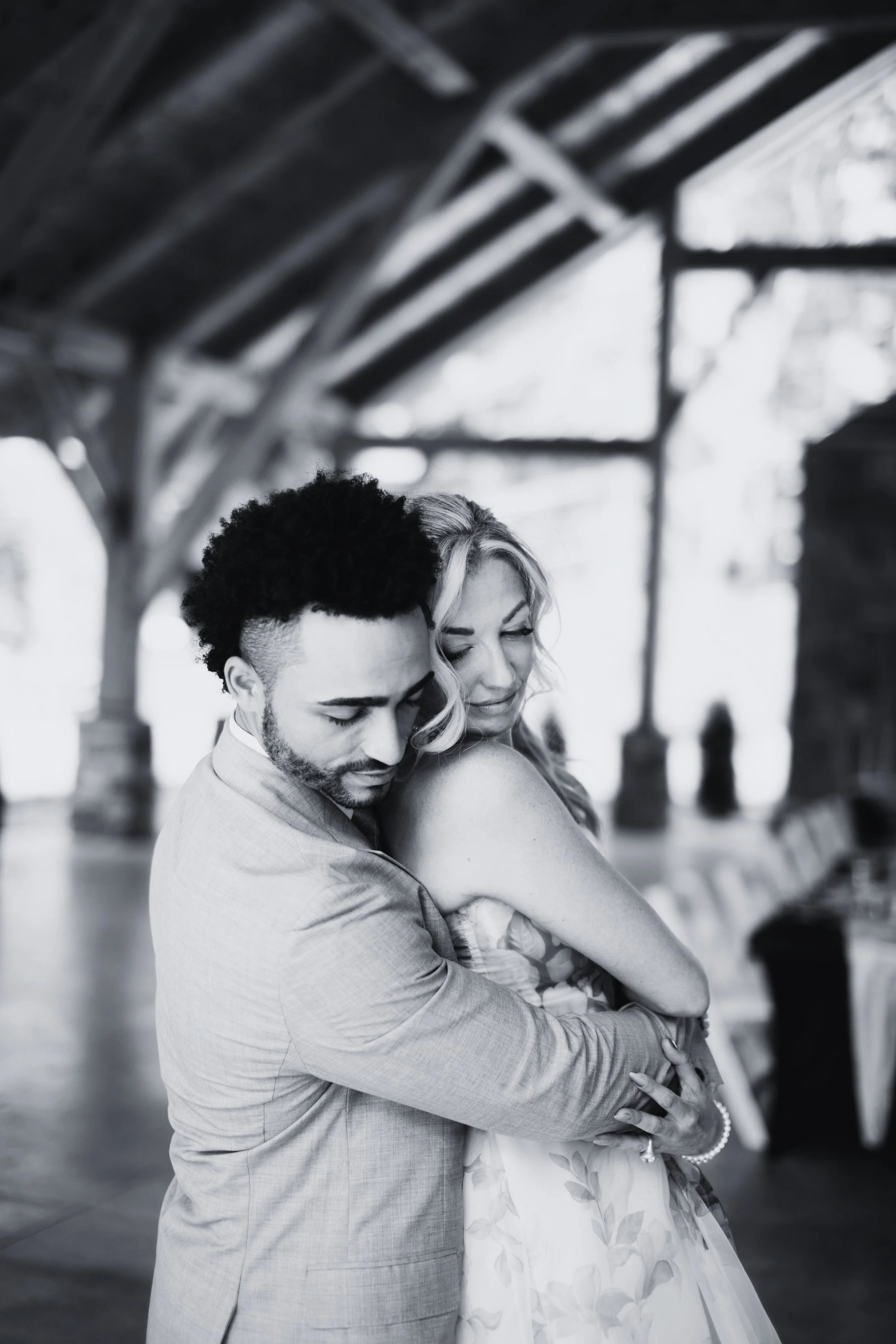 A couple embracing in a rustic venue, black and white photo.
