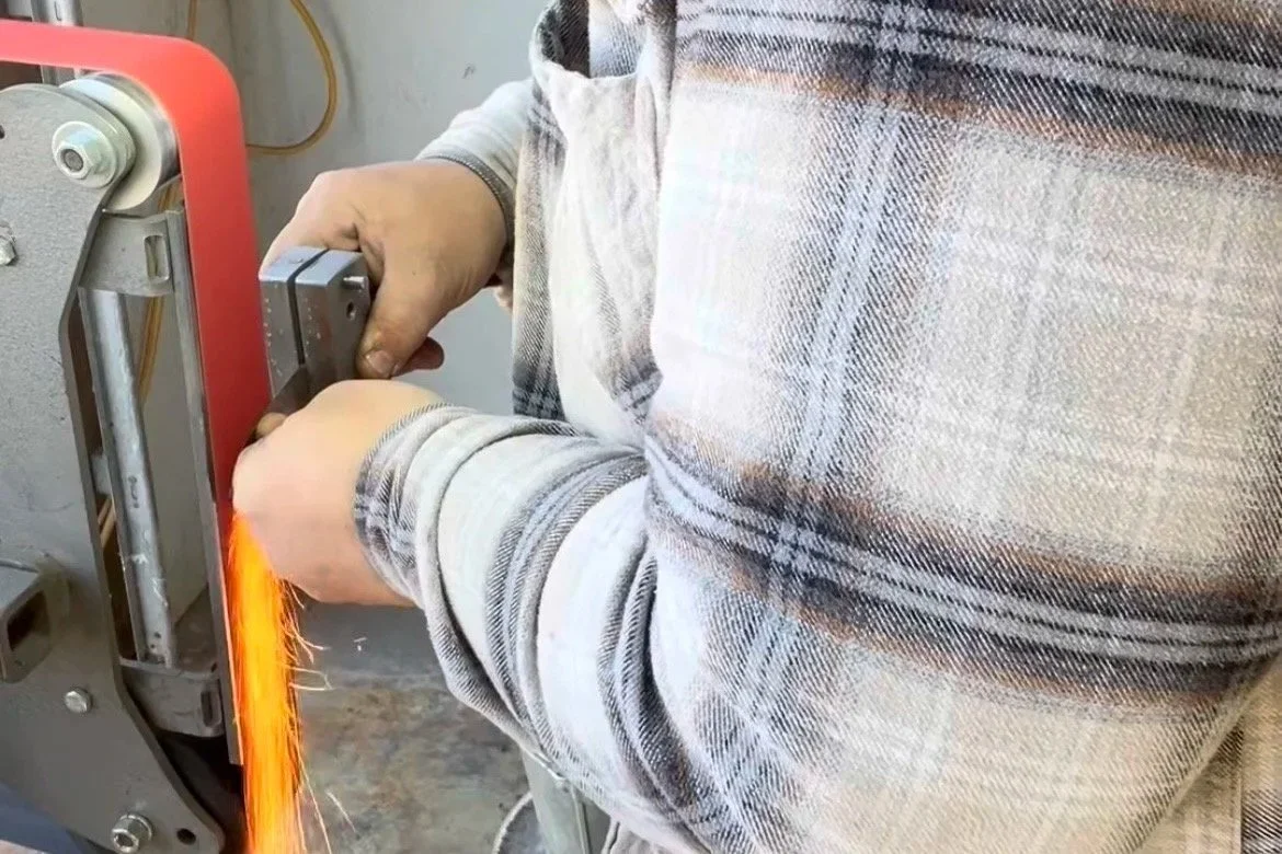 Zeke Ziegler grinding a stock removal knife blade in the Deadmoose Forge workshop in Cambridge MN