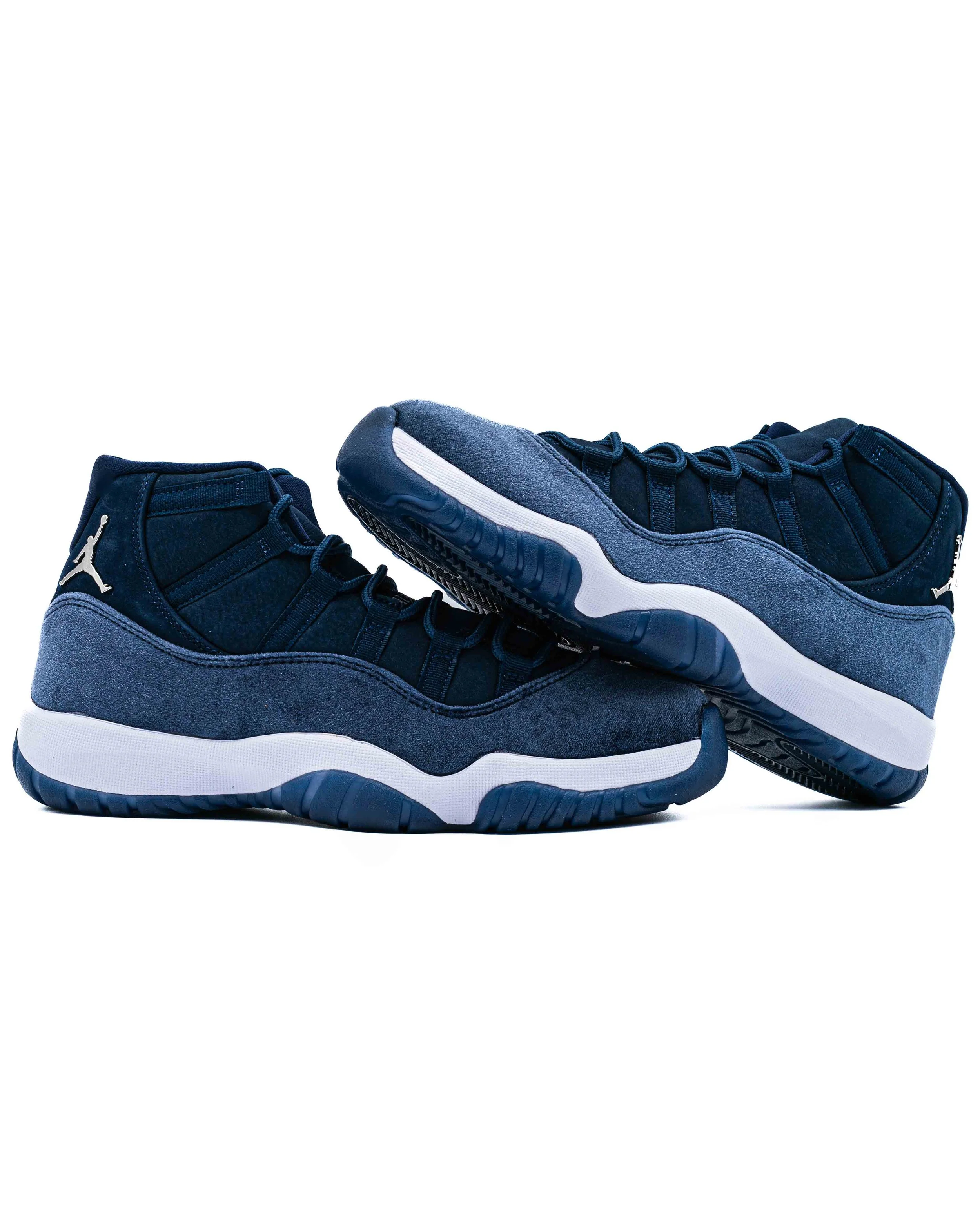 A pair of navy blue athletic sneakers with white soles, featuring the Jumpman logo on the side, set against a plain white background.