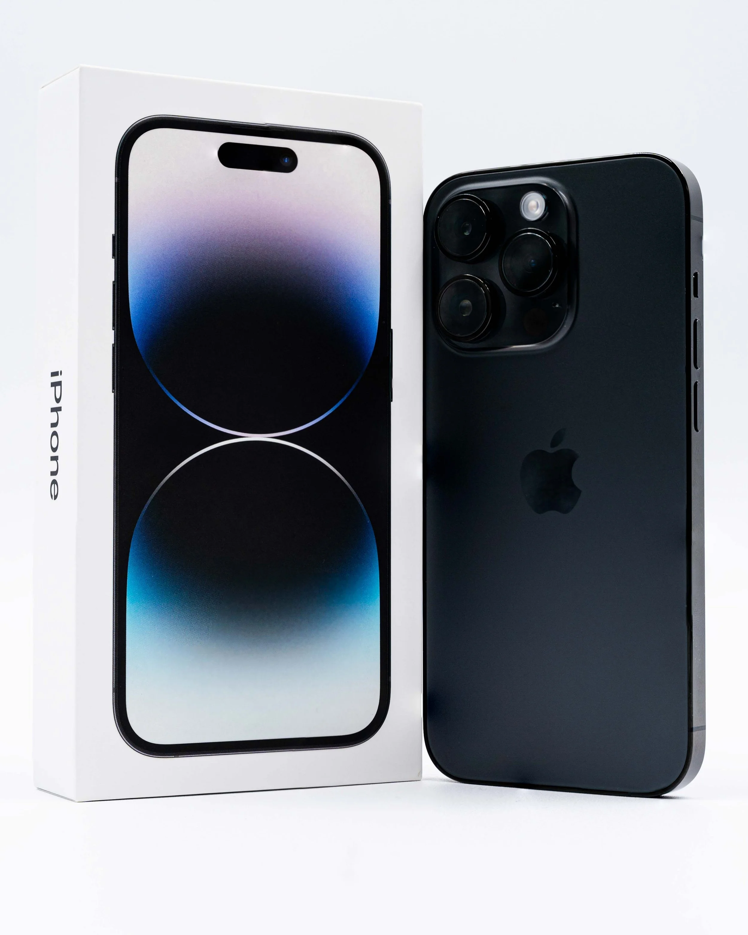 Black iPhone 14 Pro with triple camera lenses and a flash, next to its white retail box with a display image of the phone on the front.