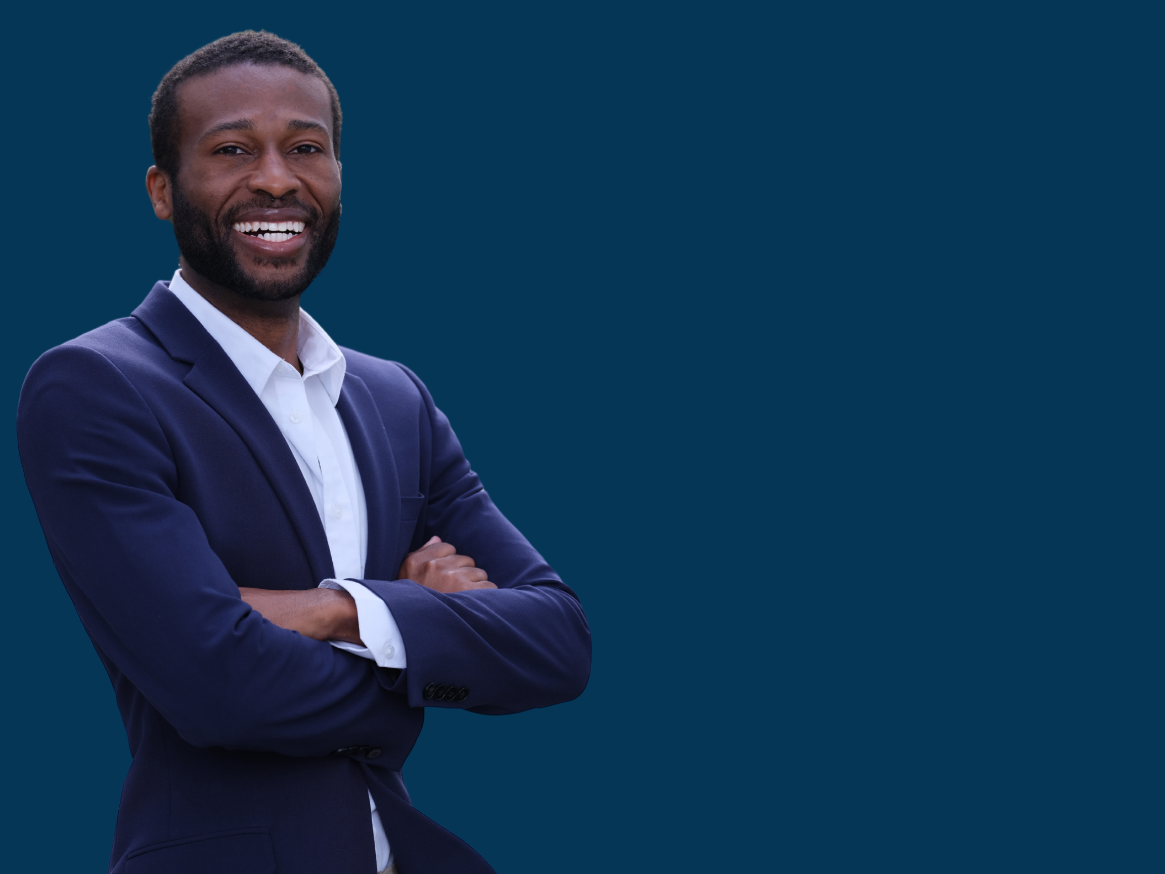 Roger Jackson wearing a navy blazer and white shirt, crossing his arms against a dark blue background.