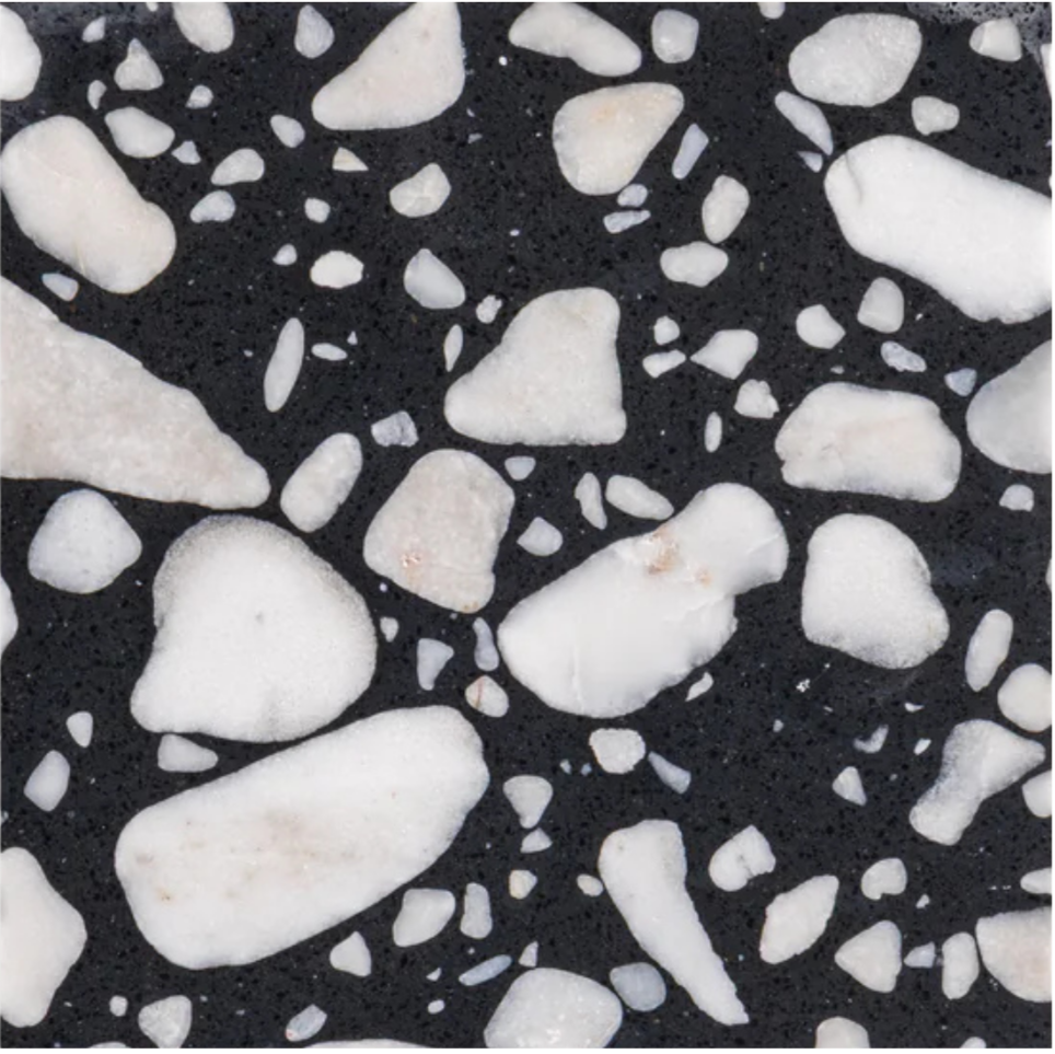 Close-up of a black terrazzo surface with white marble and granite chips embedded.