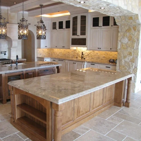 A spacious kitchen with a large central island featuring a granite countertop and wooden base, white cabinets, stone archway, and decorative hanging lantern lights.