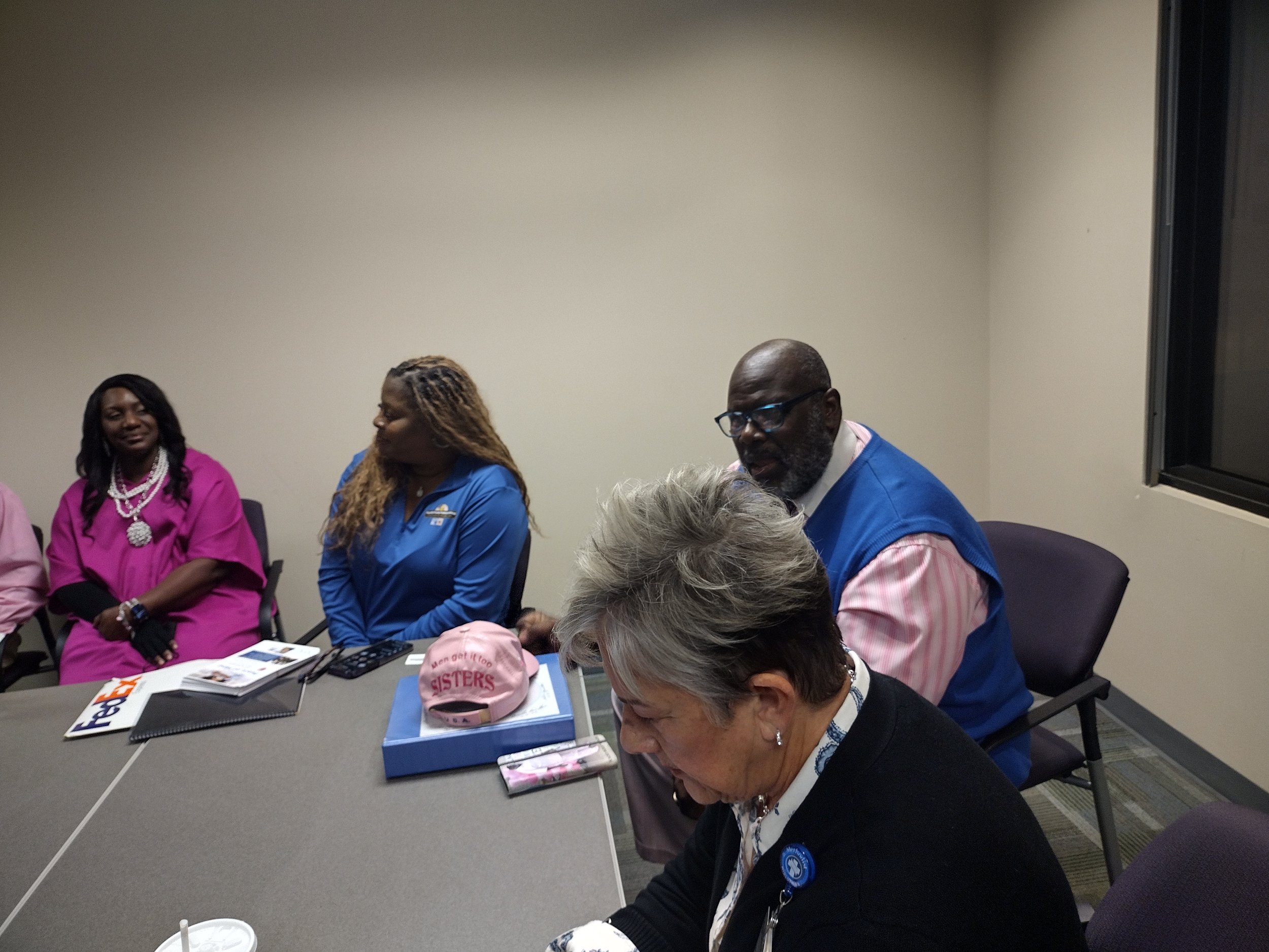 Five people sitting around a conference table in a meeting room.