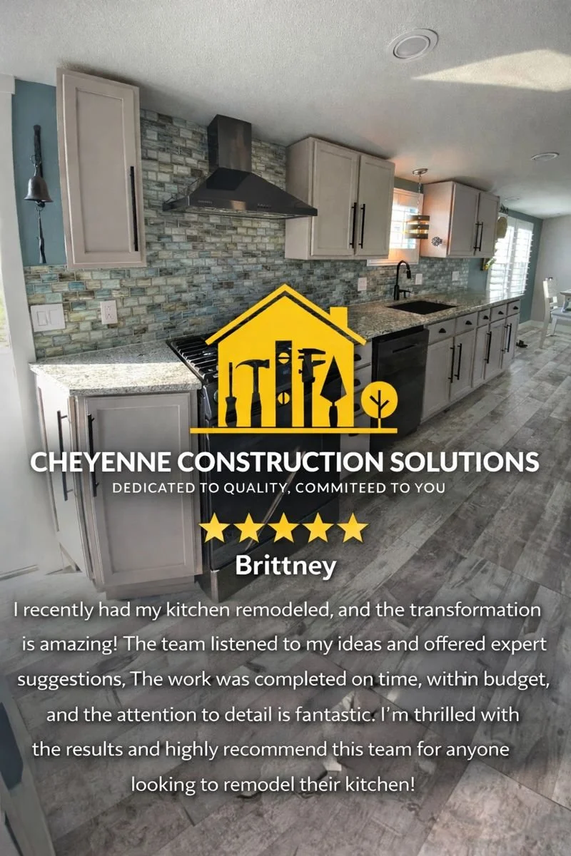 Kitchen with gray cabinets, granite countertops, stone tile backsplash, black appliances, and a dining area in the background.