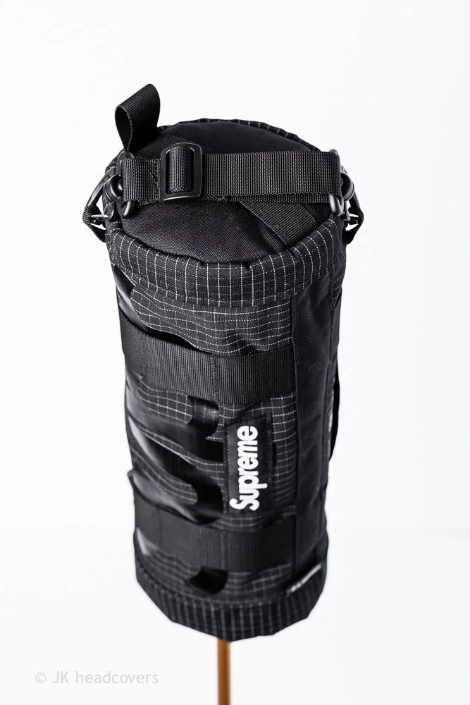 A black Supreme-branded golf bag with multiple straps and compartments, displayed against a white background.