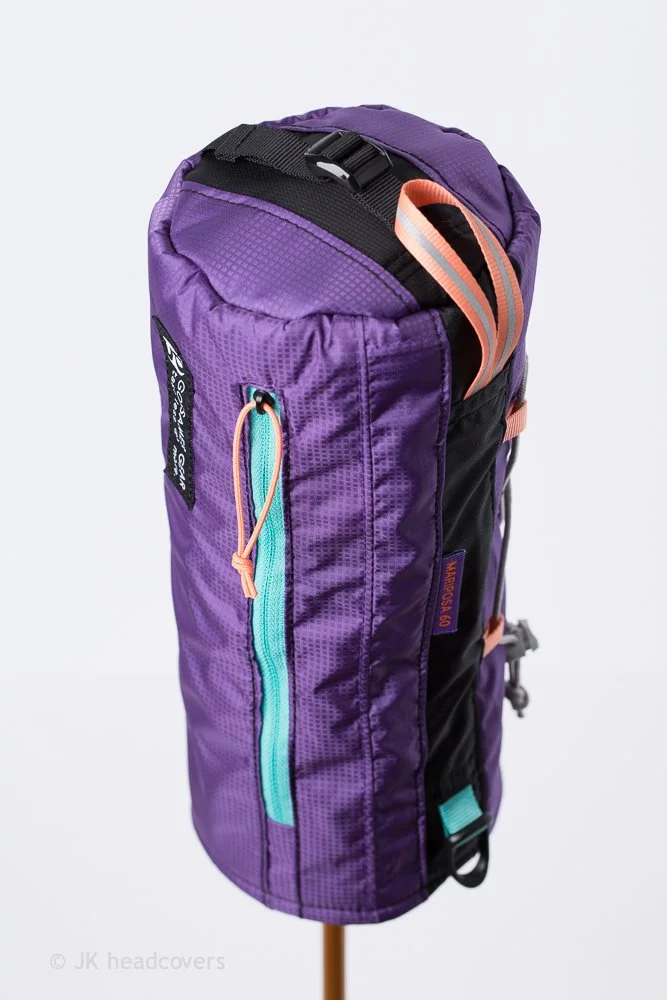 Purple and black hiking backpack with teal and peach accents, multiple compartments, and adjustable straps.