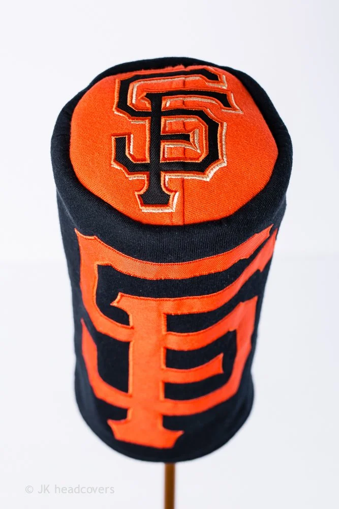 Sofa King golf putter headcover with black and orange San Francisco Giants logo.